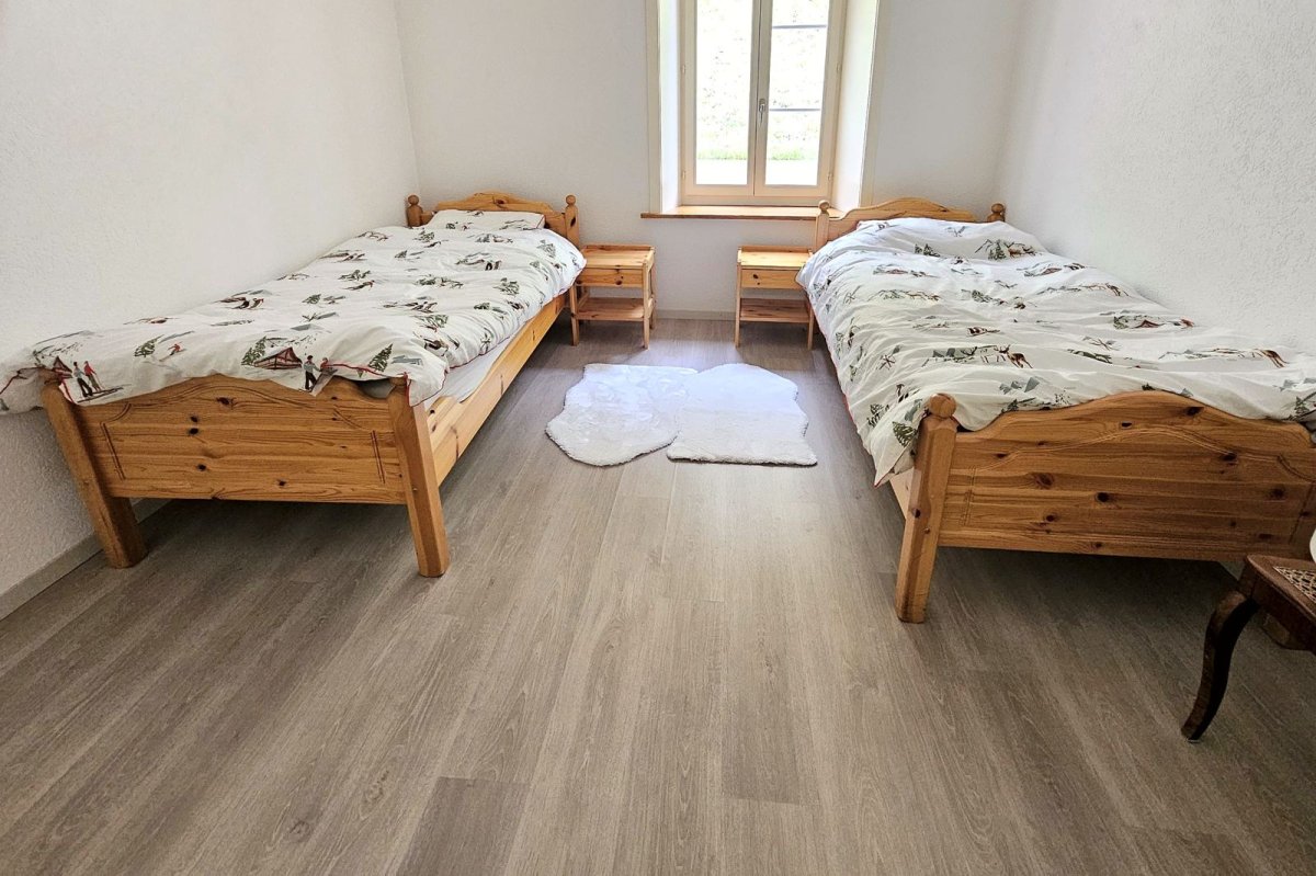 Chambre avec deux lits simples en bois miel